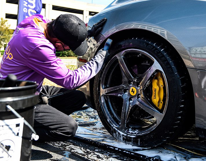 Professional mobile car detailing technician cleaning a vehicle on-site